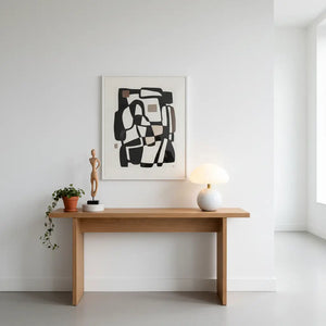 Abajur de cerâmica branco em um ambiente artístico, sobre um console de madeira clara, ao lado de uma escultura. A luminária cogumelo complementa a decoração clean