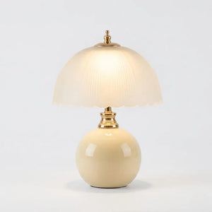 Abajur Cogumelo Limoges – luminária de mesa com base em cerâmica creme esmaltada e cúpula em vidro fosco canelado branco, ferragens douradas, acesa em fundo neutro