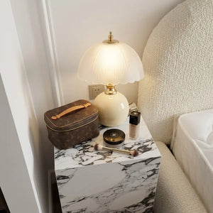 Abajur Cogumelo Limoges iluminando mesa de cabeceira de mármore em quarto com estética Quiet Luxury