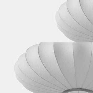 Close-up detalhado mostrando a textura do tecido e as nervuras da estrutura da luminária pendente japonesa oval em seda, destacando o acabamento do material.