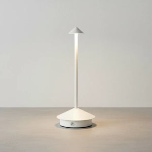 Luminária de mesa portátil sem fio na cor branca, com luz LED acesa, sobre uma superfície de concreto clara e elegante, em um fundo branco texturizado. Design clean e moderno
