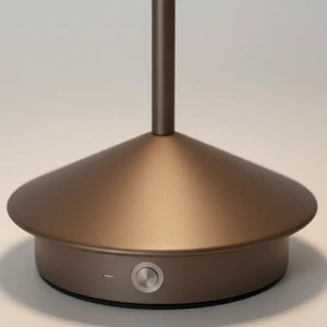 Detalhe da base da luminária de mesa portátil na cor marrom, mostrando o acabamento fosco e o botão de acionamento do dimmer