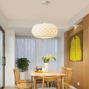 Lustre pendente Pétala branco iluminando uma mesa de jantar de madeira e cadeiras em um ambiente de design contemporâneo e biofílico