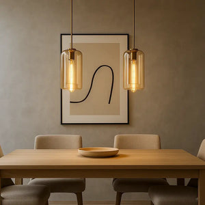 Pendente cilíndrico de vidro âmbar instalado em sala de jantar moderna com mesa de madeira