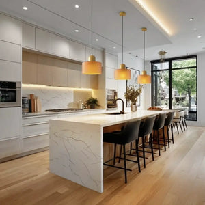 Bancada de cozinha gourmet iluminada por três lustres pendentes de vidro Laranja, criando um ponto de destaque vibrante na decoração contemporânea.