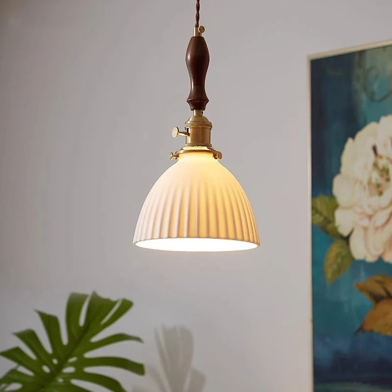 Luminária Pendente Minka de cerâmica canelada acesa em ambiente decorado