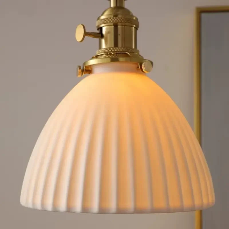 Close-up da cúpula de cerâmica canelada acesa da Luminária Pendente Minka