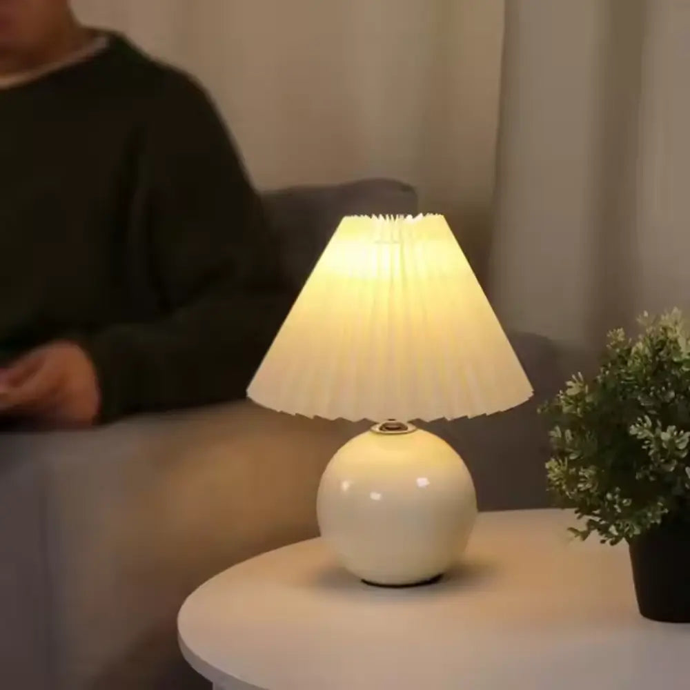 abajur de cerâmica, abajur com cúpula plissada, luminária de mesa elegante, abajur para quarto, luminária decorativa, abajur vintage moderno, abajur radiantbr, abajur minimalista, abajur com cúpula de tecido, iluminação ambiente quarto, abajur de cerâmica com tecido, abajur clássico moderno, luminária de cabeceira, luminária com LED bivolt, abajur sofisticado mesa, abajur com base redonda, luminária plissada, iluminação para decoração refinada, abajur com interruptor giratório, luminária retrô charmosa