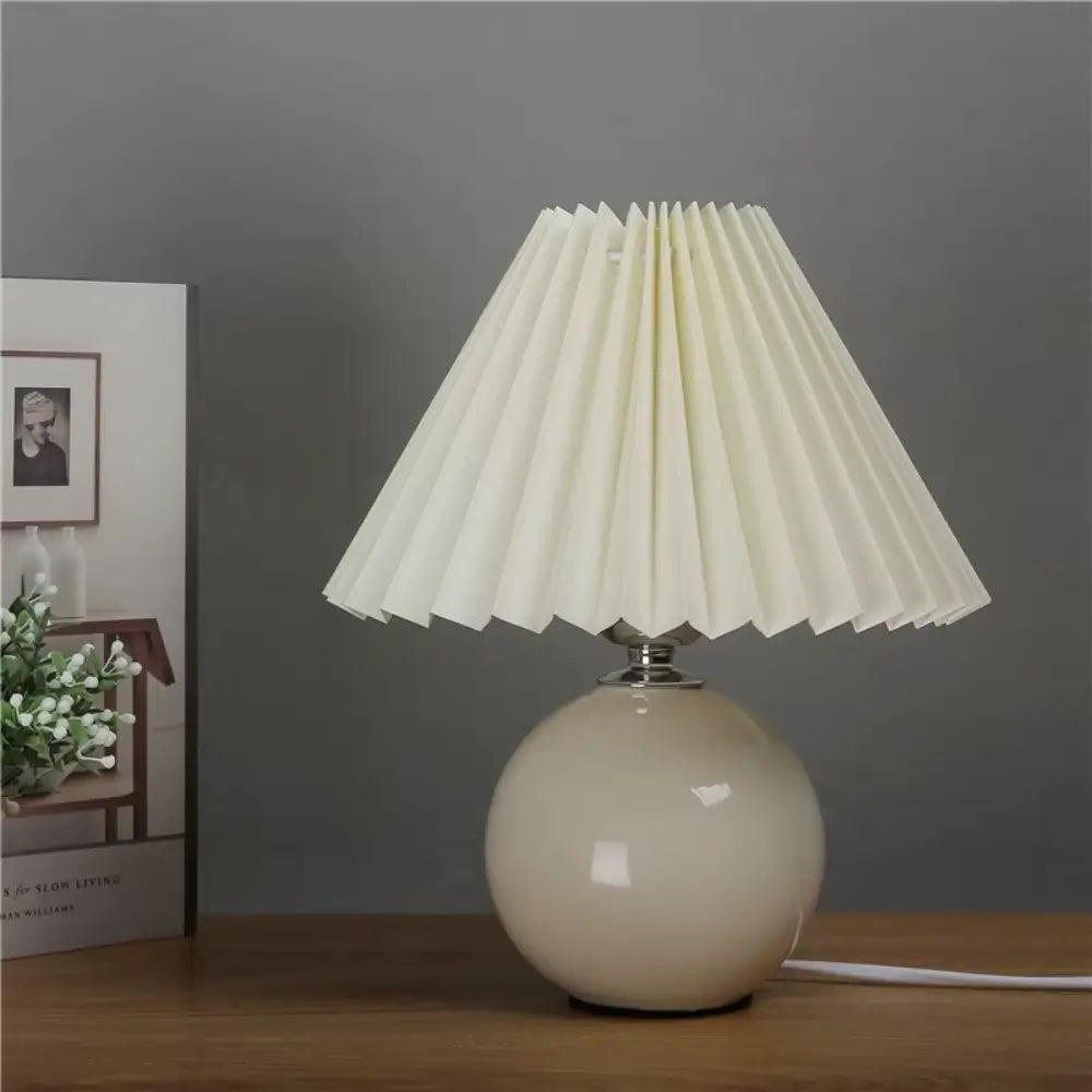 abajur de cerâmica, abajur com cúpula plissada, luminária de mesa elegante, abajur para quarto, luminária decorativa, abajur vintage moderno, abajur radiantbr, abajur minimalista, abajur com cúpula de tecido, iluminação ambiente quarto, abajur de cerâmica com tecido, abajur clássico moderno, luminária de cabeceira, luminária com LED bivolt, abajur sofisticado mesa, abajur com base redonda, luminária plissada, iluminação para decoração refinada, abajur com interruptor giratório, luminária retrô charmosa