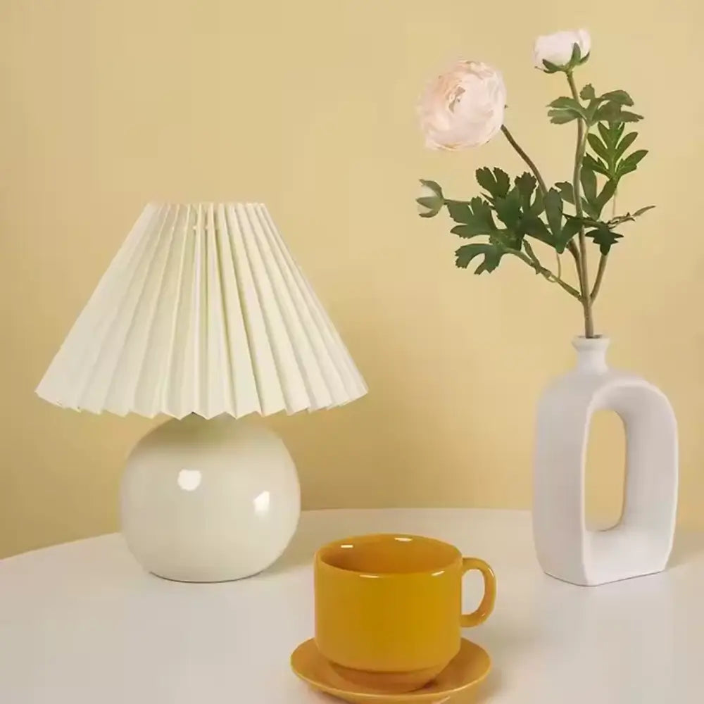 abajur de cerâmica, abajur com cúpula plissada, luminária de mesa elegante, abajur para quarto, luminária decorativa, abajur vintage moderno, abajur radiantbr, abajur minimalista, abajur com cúpula de tecido, iluminação ambiente quarto, abajur de cerâmica com tecido, abajur clássico moderno, luminária de cabeceira, luminária com LED bivolt, abajur sofisticado mesa, abajur com base redonda, luminária plissada, iluminação para decoração refinada, abajur com interruptor giratório, luminária retrô charmosa