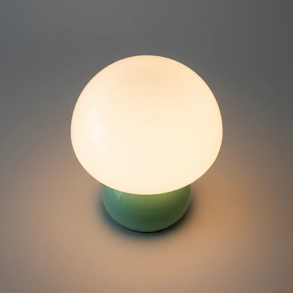 Abajur de mesa verde, mostrando a silhueta em formato de cogumelo. Design orgânico e minimalista que combina com qualquer decoração