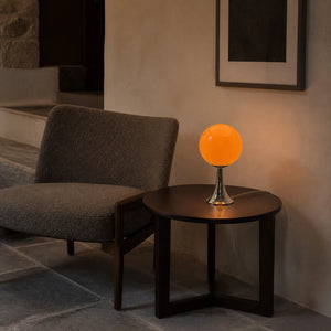 Abajur Globo Kora em canto de leitura com mesa lateral, luz baixa e fio claro visível