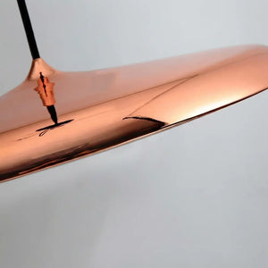 Close-up detalhado do acabamento Rose Gold (Cobre) brilhante da luminária, mostrando o reflexo de alta qualidade do metal e a curvatura perfeita do design
