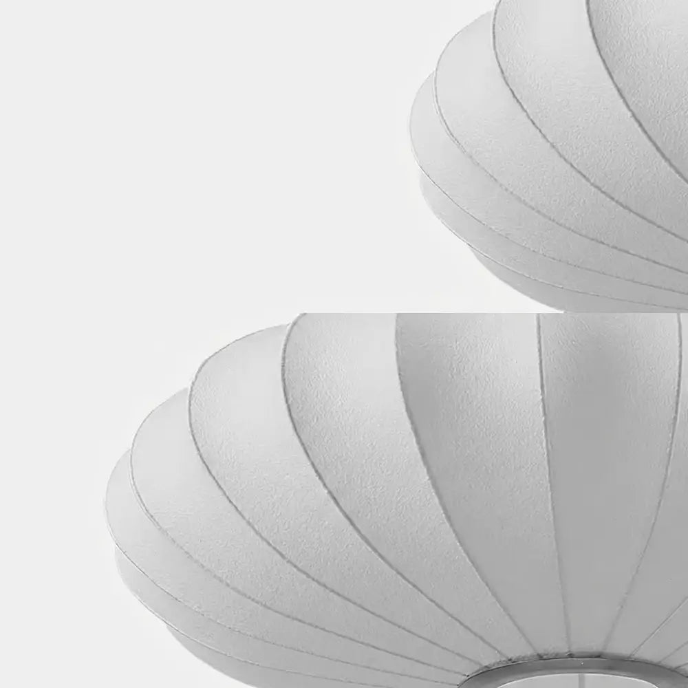 Close-up detalhado mostrando a textura do tecido e as nervuras da estrutura da luminária pendente japonesa oval em seda, destacando o acabamento do material.