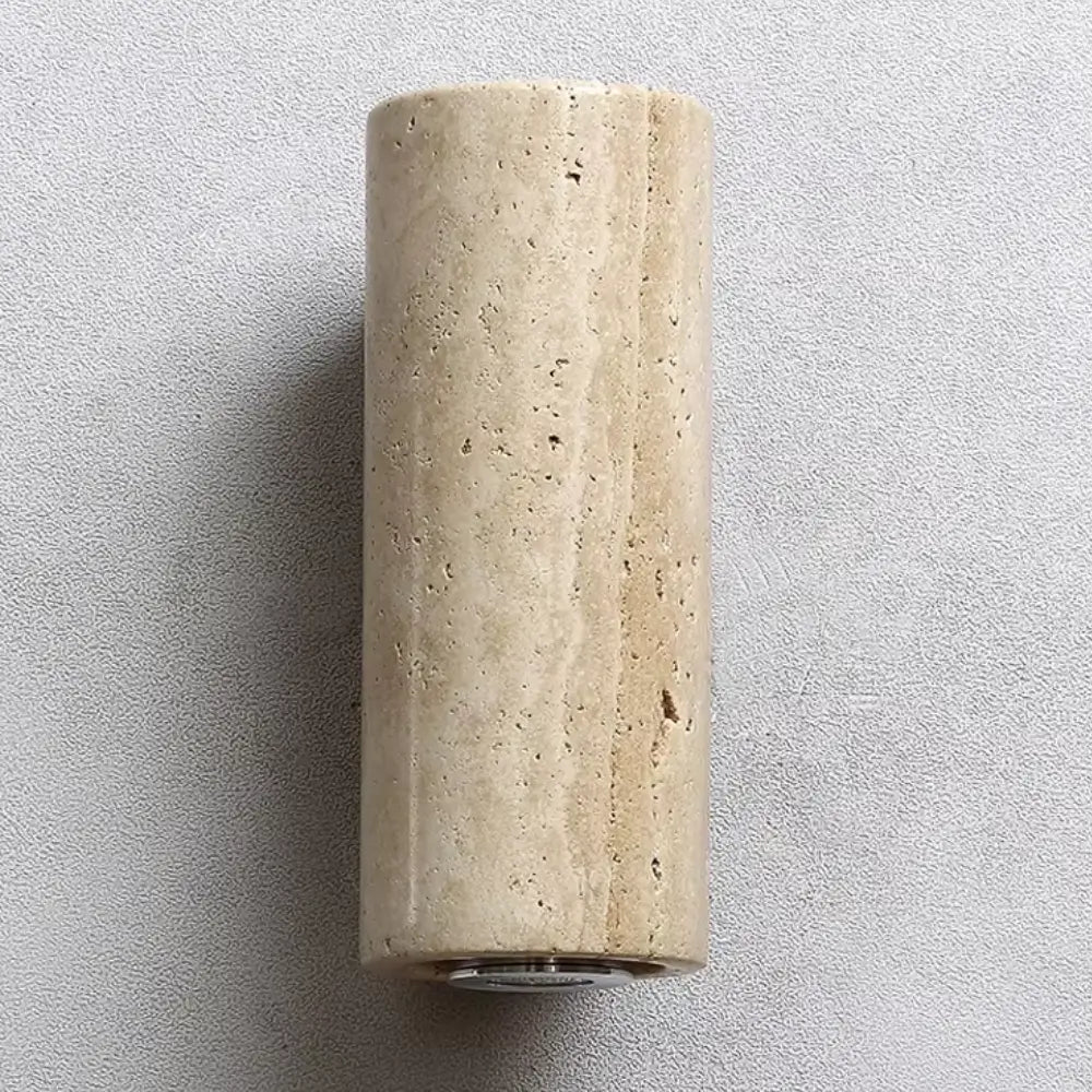 Close-up focado na textura natural e porosidade da pedra mármore travertino da arandela Siena