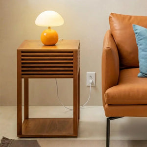 Luminária Cogumelo de design moderno decorando sala de estar, posicionada em mesa lateral ripada ao lado de sofá de couro. Objeto de destaque na decoração