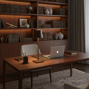 Luminária de mesa de design marrom sobre uma escrivaninha de madeira, em um escritório elegante. A luminária LED sem fio é ideal para ambientes de trabalho e estudo