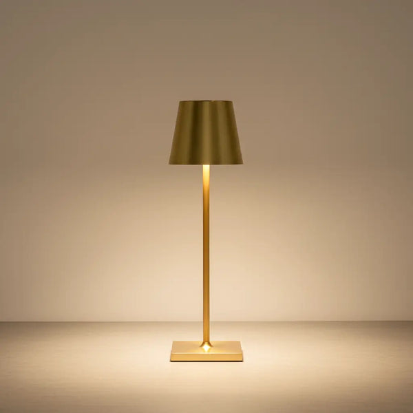 Luminária de mesa dourada de luxo com acabamento polido, com luz LED acesa, em um fundo neutro. Design elegante e alta performance