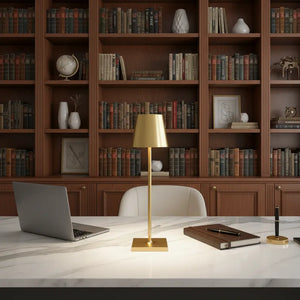 Luminária de mesa dourada em um escritório de luxo com mesa de mármore e estante de livros. A luminária LED portátil é ideal para um ambiente de trabalho sofisticado