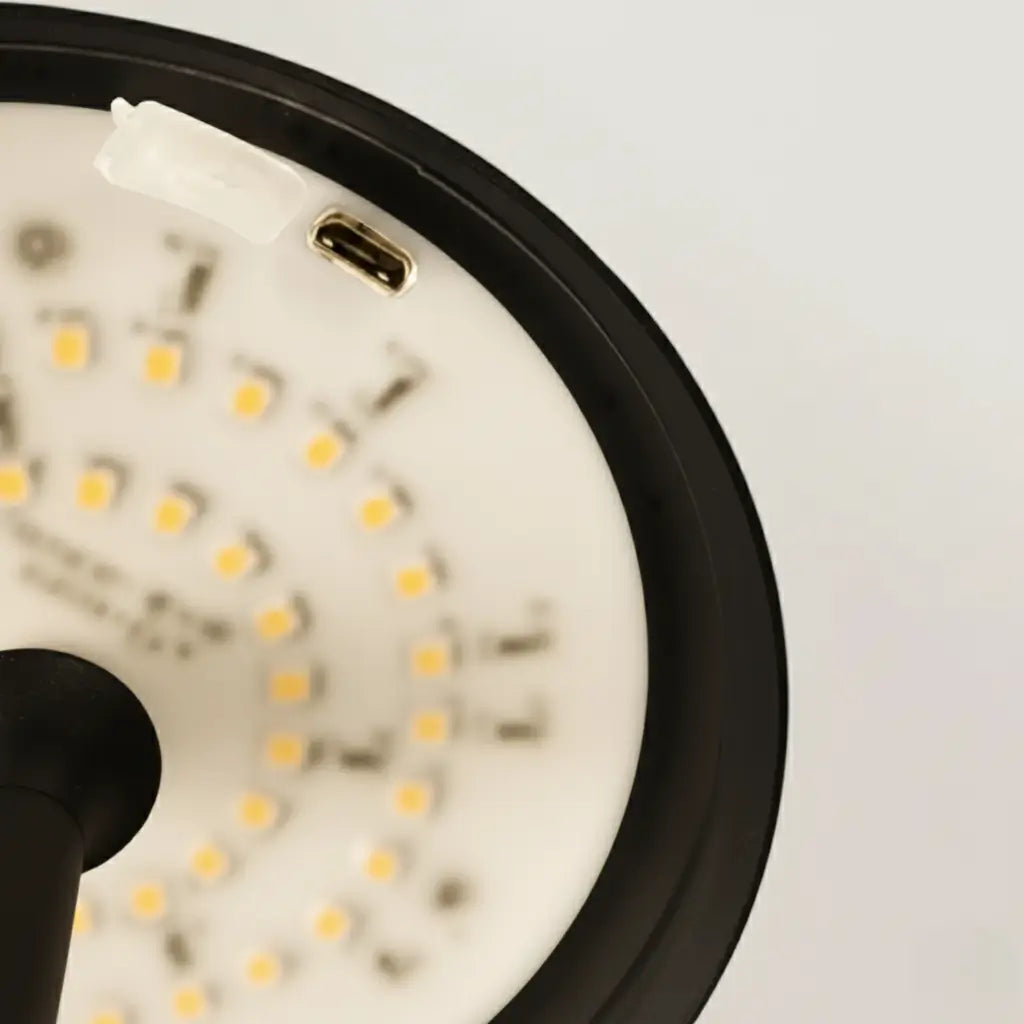 Vista técnica da parte interna da luminária de mesa preta, mostrando a tecnologia LED de alta performance e a porta de carregamento USB oculta