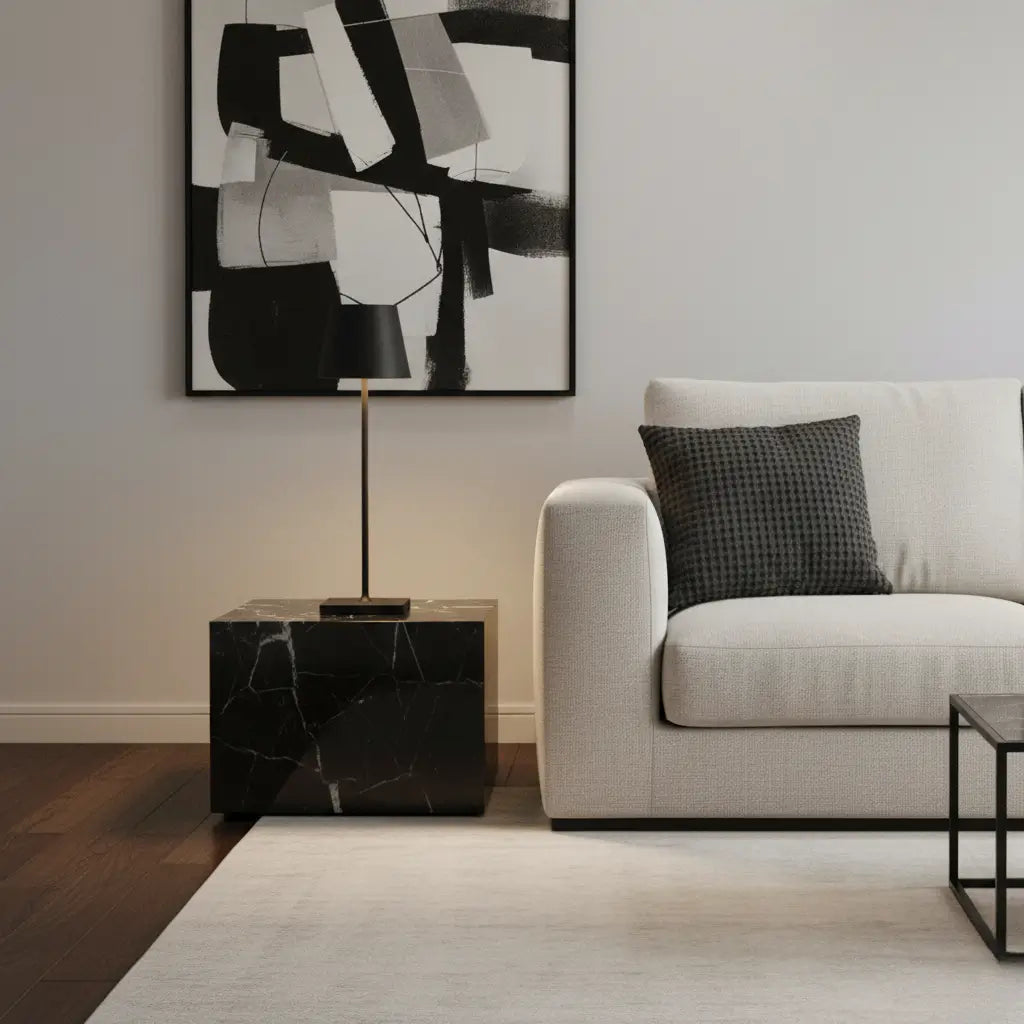 Luminária de mesa preta em uma sala de estar moderna, sobre uma mesa de mármore preto, com um sofá claro e uma obra de arte abstrata. Cria uma estética de design minimalista