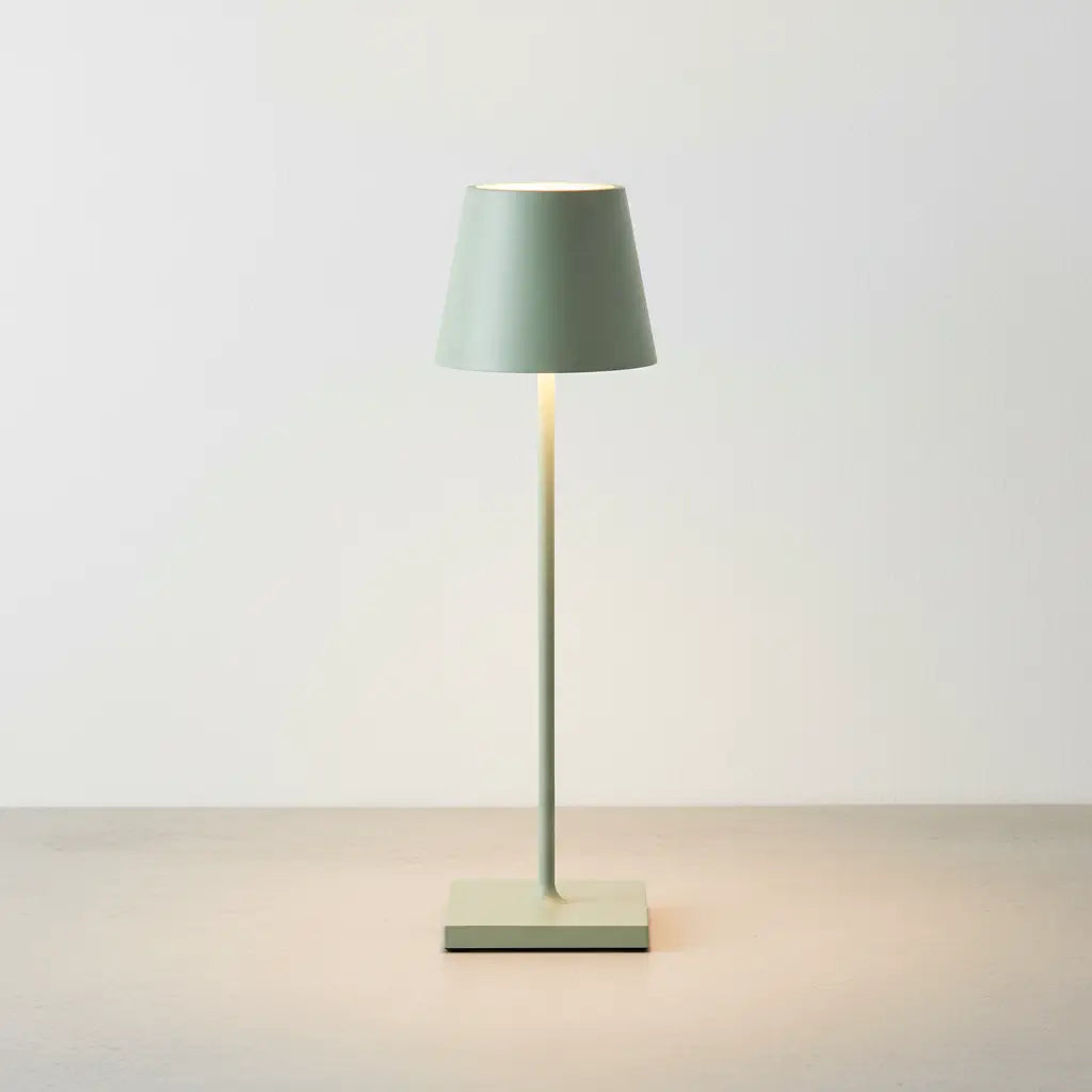 Luminária de mesa verde com acabamento fosco e design clássico, com luz suave em um fundo neutro. Representa alta performance e elegância