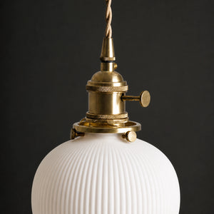 Detalhe do metal dourado e da cerâmica canelada da Luminária Pendente Maru