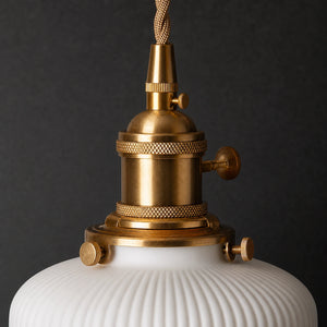 Detalhe do metal dourado e da cerâmica canelada da Luminária Pendente Taiko