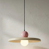 Luminária pendente moderna minimalista acesa, destacando a cúpula em metal creme e a esfera superior rosa com design retrô. Uma excelente opção de lustre colorido e elegante para sala de jantar ou quarto.