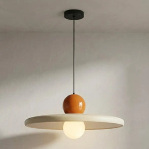 Luminária pendente moderna de estilo retrô e minimalista, modelo orbital da Série Cream. Cúpula principal em metal laqueado creme fosco com a meia-esfera superior em terracota laranja queimado. Possui cabo trançado marrom e detalhes dourados. Visão frontal isolada contra fundo branco. Ideal como lustre moderno para sala de jantar.