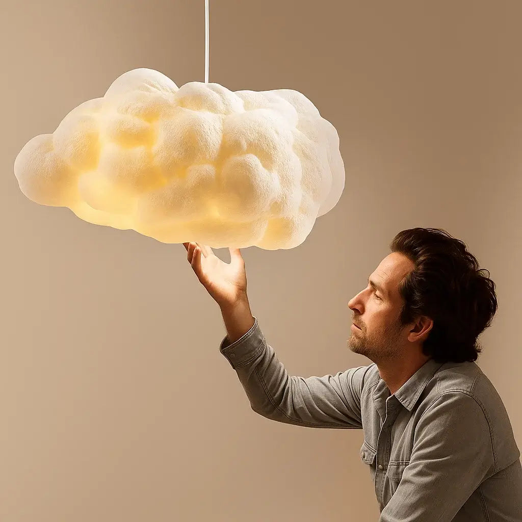 Detalhe da luminária nuvem Nimbus sendo segurada por adulto, evidenciando textura realista de algodão à prova de fogo
