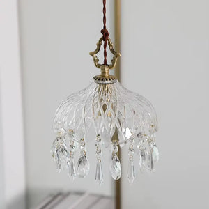 Luminária pendente de vidro facetado tipo cristal Marquise da Radiantbr com a luz apagada, destacando a transparência dos pingentes em gota e a estrutura dourada superior.