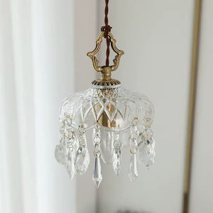 Luminária pendente de vidro facetado tipo cristal Marquise da Radiantbr com a luz apagada, revelando o soquete dourado interno e a transparência dos pingentes sob luz natural.