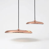 Lustre Pendente Macaron Nordic em acabamento Rose Gold (Cobre) brilhante. Design moderno em formato de disco ultrafino com LED integrado, ideal para salas de jantar sofisticadas e ambientes de luxo