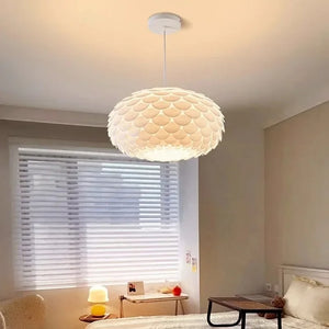 Luminária pendente moderna branca instalada sobre a cama em um quarto de casal com decoração minimalista estilo escandinavo.